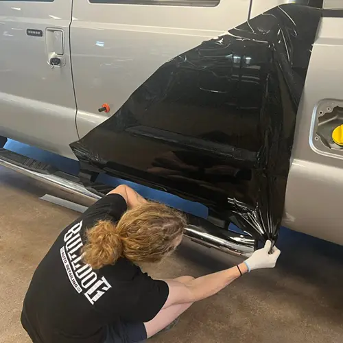Team applying vinyl wrap to a truck.
